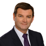 Porträt eines Mannes in einem Anzug mit Krawatte, lächelnd und professionell.