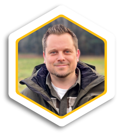 Porträt eines Mannes mit kurzer Frisur in einem Parka. Er lächelt freundlich.